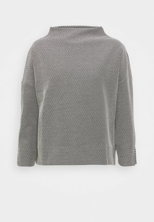 Top de manga larga con estampado en blanco y negro, cuello redondo alto y corte holgado sobre un fondo blanco liso.