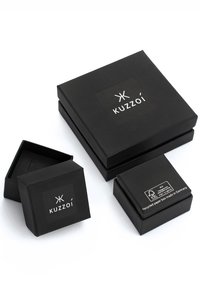 Black cardboard gift boxes of various sizes, featuring a logo label. Boxes have smooth texture and are made from recycled paper.