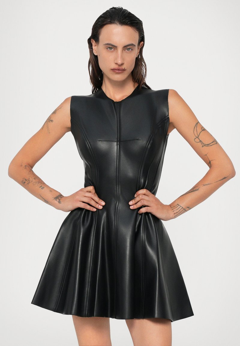 Black sleeveless dress made of shiny faux leather, featuring a fitted bodice and flared skirt with vertical seams and a front zipper.
