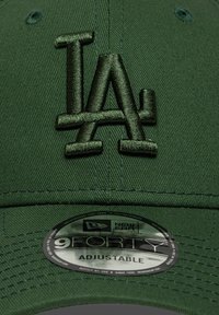 Πράσινο ρυθμιζόμενο καπέλο με κεντημένο λογότυπο "LA" στο ίδιο πράσινο χρώμα. Περιλαμβάνει κυκλικό ταμπελάκι με τις επιγραφές "New Era" και "9FORTY".