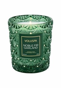 Grön ljuslykta med strukturerat glas som har bladmönster, gyllene accenter och en etikett som står "Voluspa Noble Fir Garland." Kokosvax.