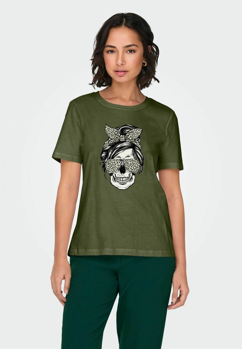 T-shirt à manches courtes vert olive avec un design graphique d'un crâne portant des lunettes et un bandeau. Tissu en coton, coupe décontractée.
