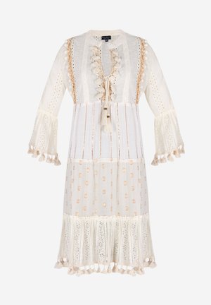 Hvid kjole med blonde detaljer, broderede accenter og gyldne prikker. Har klokkeærmer og en flæse-nederkant med frynsekanter.