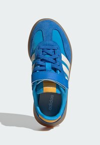 Blue athletic shoe with suede and mesh materials, featuring white stripes, lace-up closure, and a padded tongue. Rubber sole and orange accent.