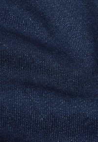 Donkerblauwe denimstof met een gladde textuur en zichtbaar weefpatroon, met lichte variaties en spikkels voor detail.