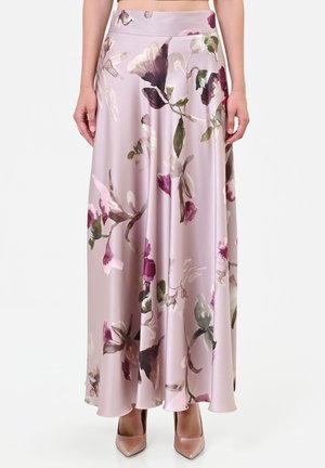 Gonna lunga in raso con vita alta e grande motivo floreale nelle tonalità di viola, verde e bianco, indossata con scarpe nude con punta.
