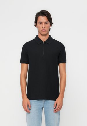 Polo shirt noir à manches courtes avec un col zippé, fabriqué en tissu lisse. Coupe ajustée, design minimaliste, sans motifs ni accents visibles.