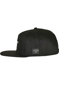 Mustan lamedega snapback müts, valmistatud tekstureeritud kangast. Külgedel on logo plaastr ja esiküljel tikitud tekst.