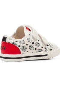 Scarpa da ginnastica bianca con dettagli rossi, caratterizzata da impronte di cane nere e grigie e pois, con strap in velcro e suola in gomma testurizzata.