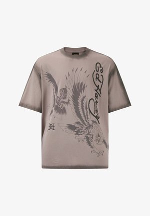 Hnědý krátký rukáv tričko s grafickými prvky šedého orla a draka, se stylizovaným nápisem "Ed Hardy". Měkká tkanina s volným střihem.