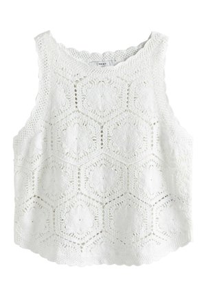Biely háčkovaný top bez rukávov so šesťuholníkovými kvetinovými vzormi a zvlnenými okrajmi, s označením "NEXT" na vnútornom golieri.