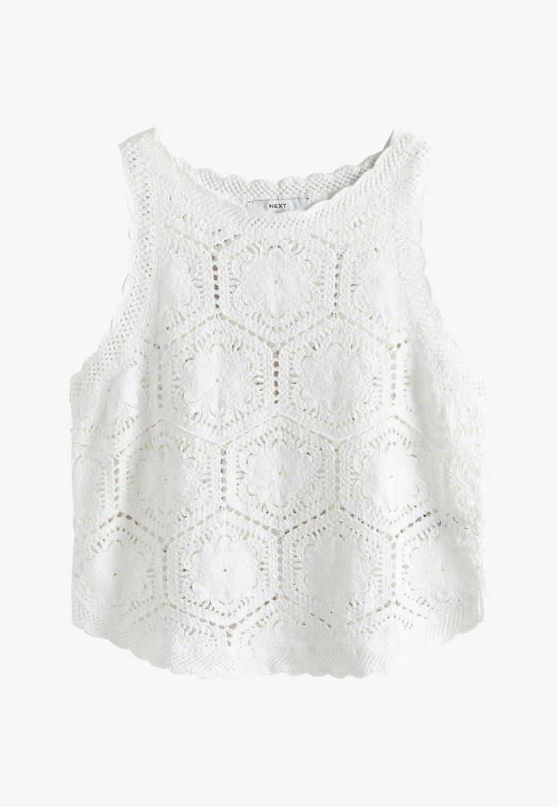 Haut blanc sans manches en crochet avec des motifs floraux hexagonaux et des bords en feston, étiquette « NEXT » à l'intérieur de l'encolure.