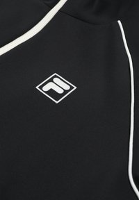 Sort stof med hvide kanter og en lille hvid logo, der ligner to geometriske former inde i en diamantformet ramme.