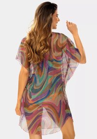 Przezroczysty, wielokolorowy pareo o zwiewnym fasonie, z wirującymi wzorami w odcieniach fioletu, niebieskiego, pomarańczowego i zielonego. Lekka tkanina.