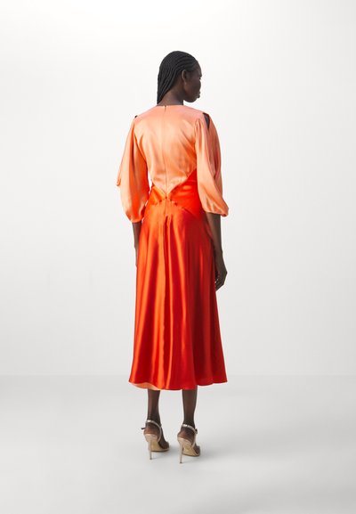 Satinorange klänning med puffärmar och en figurnära bodice. Midilängdssiluett med en mjuk textur och en utsvängd kjol.