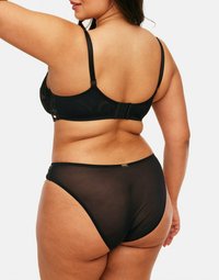 Ensemble de lingerie noir comprenant un soutien-gorge en dentelle avec des bretelles réglables et une fermeture à crochet et œil, associé à une culotte noire transparente avec un accent subtil.