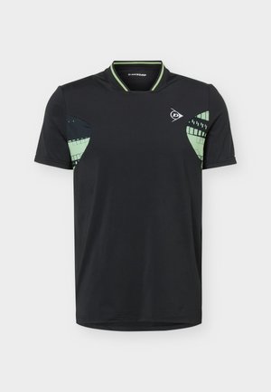 T-shirt de sport noir à manches courtes avec des motifs géométriques verts et noirs sous les bras et un petit logo blanc Dunlop sur la poitrine.