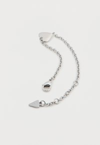 Bracelet en chaîne argentée avec une fermeture en forme de cœur et un pendentif triangulaire. Comprend des maillons entrelacés et une finition polie.