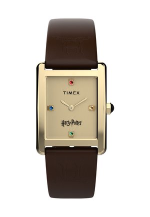 Montre Timex Harry Potter avec boîtier rectangulaire doré, cadran beige, index des heures en pierres précieuses colorées, et bracelet en cuir marron embossé du blason de Poudlard.