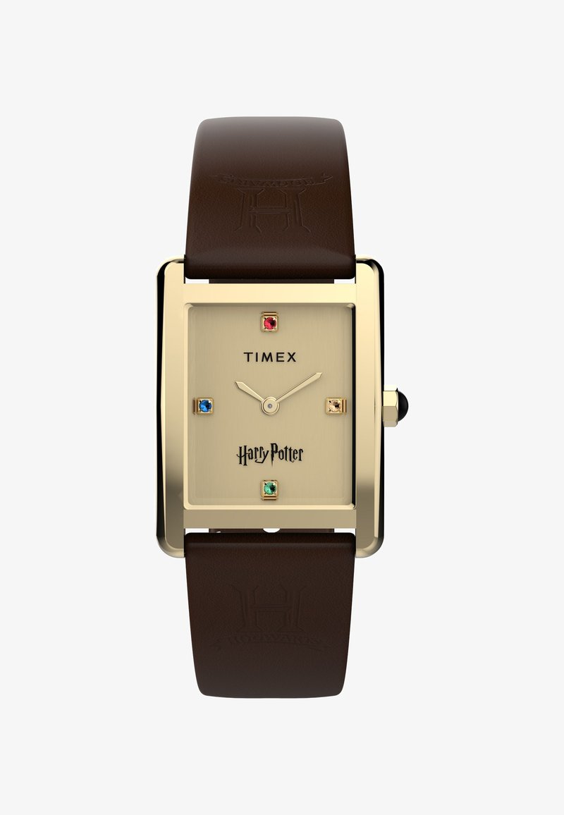 Montre Timex Harry Potter avec boîtier rectangulaire doré, cadran beige, index des heures en pierres précieuses colorées, et bracelet en cuir marron embossé du blason de Poudlard.