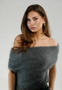 Grå, off-shoulder strikket sweater med en blød, fuzzy tekstur. Har en bred halsudskæring og en afslappet pasform, der fremhæver det glatte stof.