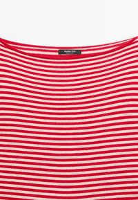 Rood-wit gestreept kledingstuk met een zwart label met de tekst "Massimo Dutti Made in China" bij de halslijn.
