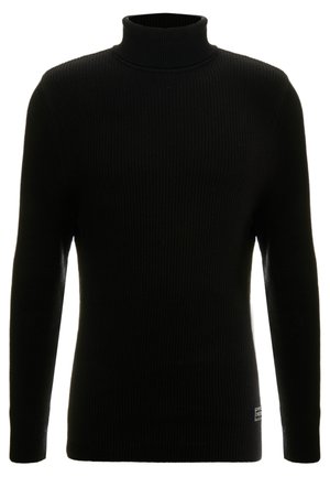Pull à col roulé noir avec des manches longues, texture côtelée, silhouette ajustée et petite étiquette de marque en bas à gauche.