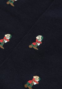 Tmavě modrá látka s opakujícím se designem pohádkových trpaslíků v zelené a červené barvě, s hladkou texturou a hravým vzorem po celé ploše.