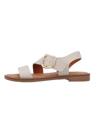 Beige flache Ledersandale mit einem breiten Vorderriemen, einem Knöchelriemen mit großer goldener Schnalle und einer niedrigen braunen Sohle.