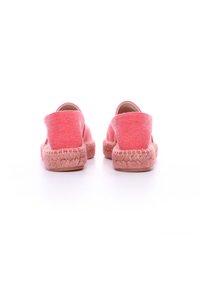 Espadrillas in tela rosa con suole in juta intrecciata. Presentano un design senza tallone, una texture liscia e un'apertura rotonda per facilitarne l'indossamento.