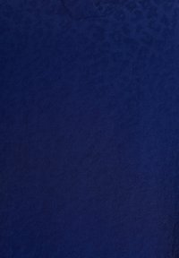 T-shirt bleu marine avec un motif léopard texturé subtil, doté d'un col en V et d'un tissu léger et doux.