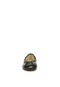 Black leather flat shoe with a rounded toe, featuring a small bow accent and metal detail, smooth texture, and minimalistic design.