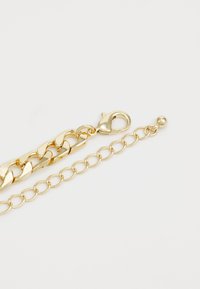 Gold chain bracelet featuring interlocking links and a lobster clasp. Includes an adjustable chain with a ball accent at the end.