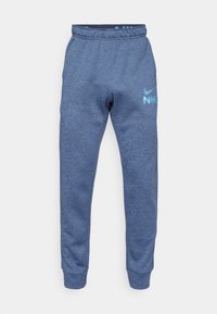 Blauwe Nike trainingsbroek van textuur fleece. Kenmerkt zich door een elastische tailleband, taps toelopende benen en een contrasterend lichtblauw logo op de dij.