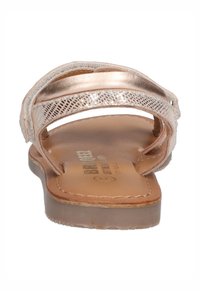 Roze gouden platte sandalen met gestructureerde banden en een zachte bruine binnenzool. De bovenkant heeft een geweven metallic ontwerp en gladde, glanzende accenten.