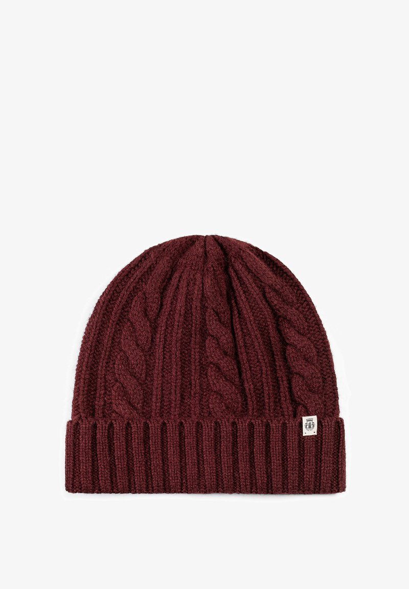 Maroon knitted beanie with textured cable knit pattern and ribbed hem. Features a small logo tag on the side. Soft acrylic material.