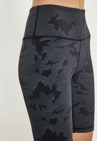 Fekete és sötétszürke kamuflázs mintás, magas derekú sportshorts, sima tapintással és megerősített varrásokkal az illesztéseknél.