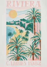 Camiseta con un gráfico vibrante de una escena de playa con palmeras, montañas y un gran sol. Los colores incluyen verde, azul, amarillo y rosa.