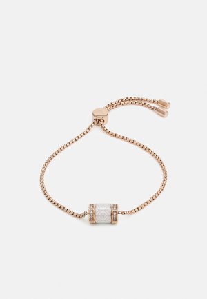 Delicate rose gold adjustable chain bracelet with a white cylindrical bead featuring geometric patterns and small embedded crystals.