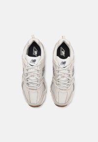 Lichtgekleurde hardloopschoenen met een bovenwerk van mesh, vetersluiting en rubberen zool. Voorzien van een logo op de tong en zijpanelen in contrasterende kleuren.