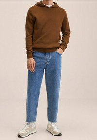 Bruine geribde hoodie, lichte denim jeans met een rechte snit en beige sneakers met witte accenten en veters. Minimalistisch ontwerp.