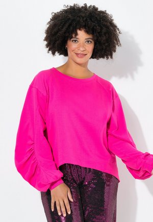 Fuchsia sweatshirt met lange, opgeblazen mouwen en een ronde halslijn. Gecombineerd met glanzende zwarte paillettenbroek. Soepele textuur, casual ontwerp.