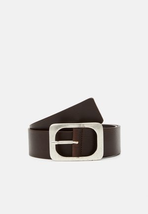 Ciemnobrązowy skórzany pasek zwinięty z dużą prostokątną srebrną metalową klamrą na jasnoszarym tle.