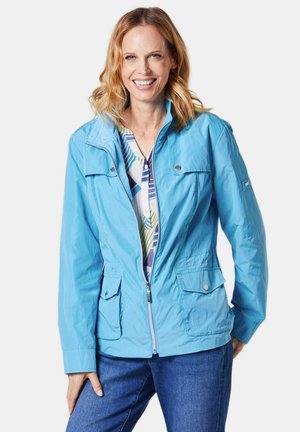 Veste légère bleu clair, résistante à l'eau, avec fermeture éclair, deux poches avant, capuche réglable et accents en bouton. Offre une coupe décontractée.