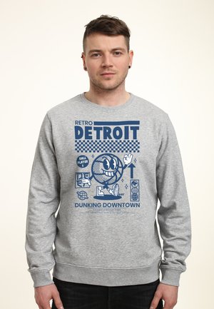 Szary sweter z retro wzorem graficznym. Wzór zawiera uśmiechniętą postać koszykówki oraz napis "DETROIT" w pogrubionym niebieskim tekście.