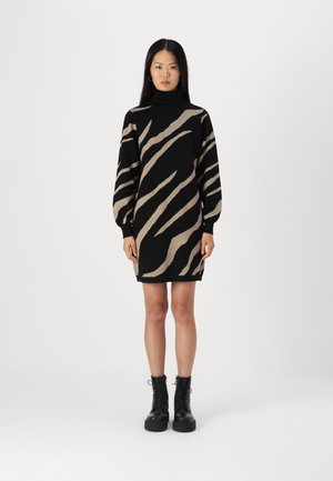 Knit dress featuring a black base with contrasting beige zebra stripes, turtleneck, and long puff sleeves. Worn with black lace-up boots.