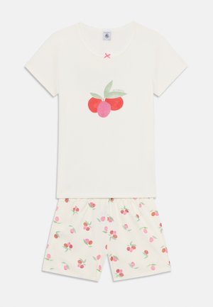 Set de pijamale crem cu mânecă scurtă, având un grafic cu cireșe pe partea de sus și pantaloni scurți cu un model de cireșe roz, confecționat dintr-un material moale.