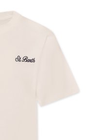 T-shirt in cotone crema con maniche corte, scollatura rotonda e testo ricamato blu scuro "St. Barth" sul lato sinistro del petto.