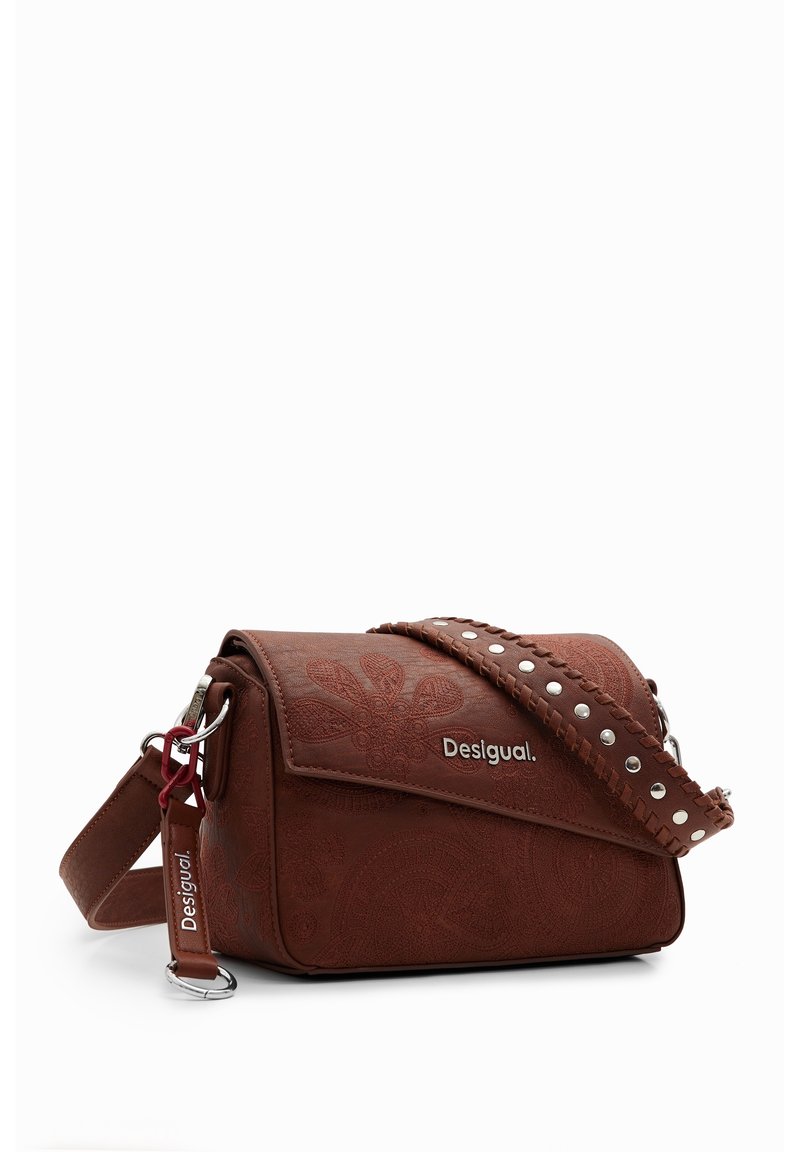 Brun läder crossbody-väska med präglade blommönster, silverfärgad hårdvara och en nitar strap. Logotypen visas på framsidan.