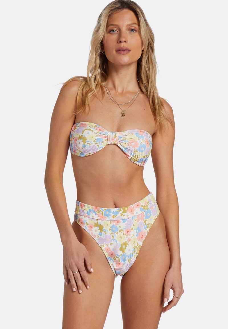 Dwuczęściowy strój kąpielowy w kwiaty, z biustonoszem typu bandeau z detalem w postaci węzła oraz wysokimi majtkami. Kolory obejmują pastelowe odcienie różu, żółci i niebieskiego.